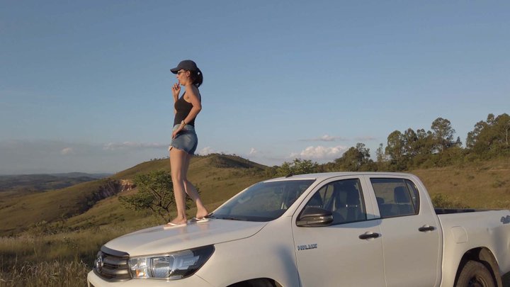 Bruna dances on the roof and hood of a Hilux and also revvs it hard